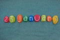 23 January,ÃÂ calendar date composed with multi colored stones over green sand